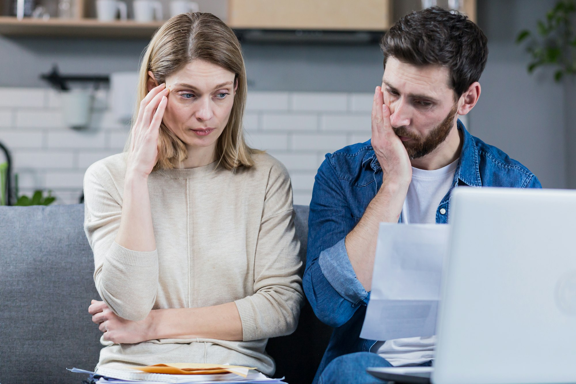 Man and woman, young family together intently reading a letter, frustrated